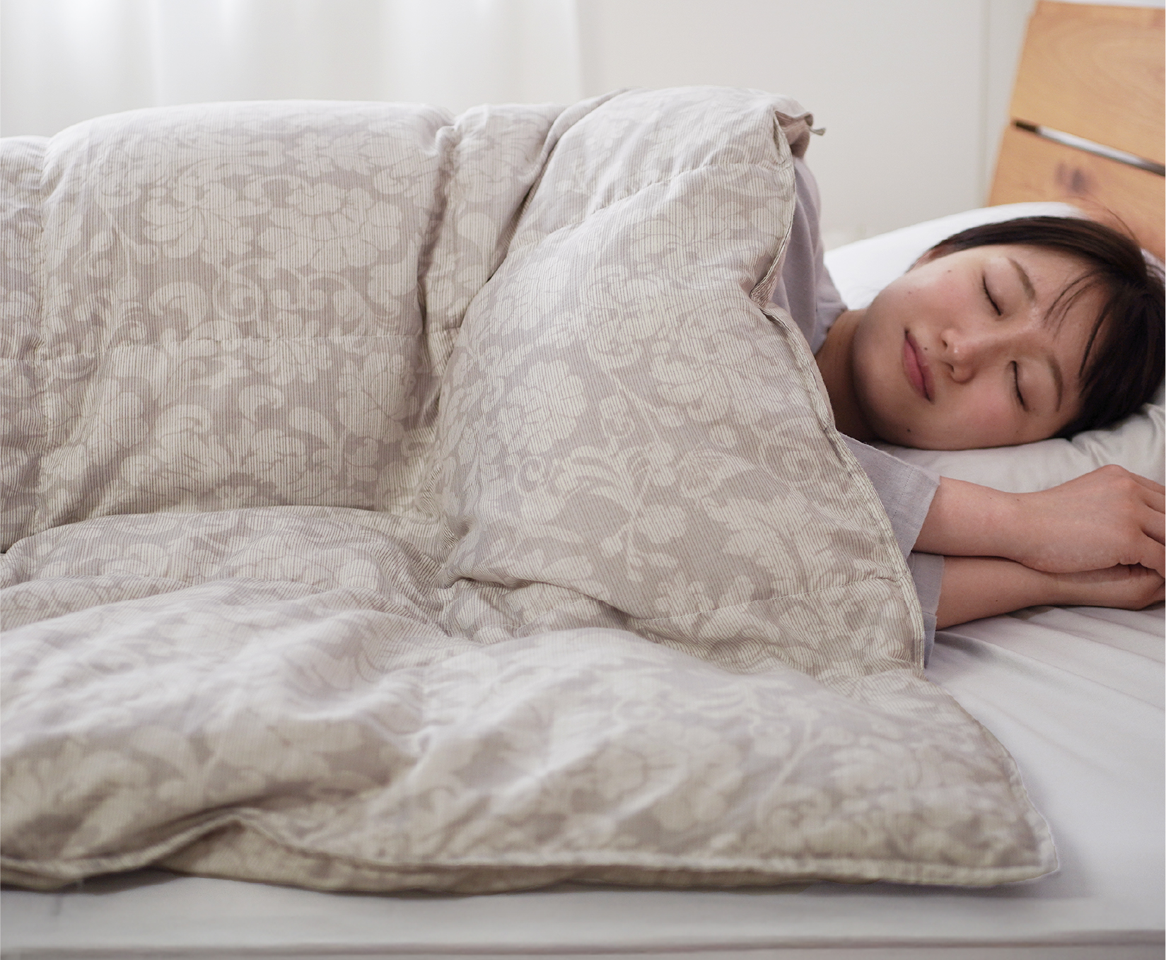 しあわせふとんに包まれて気持ちよさそうにしている女性